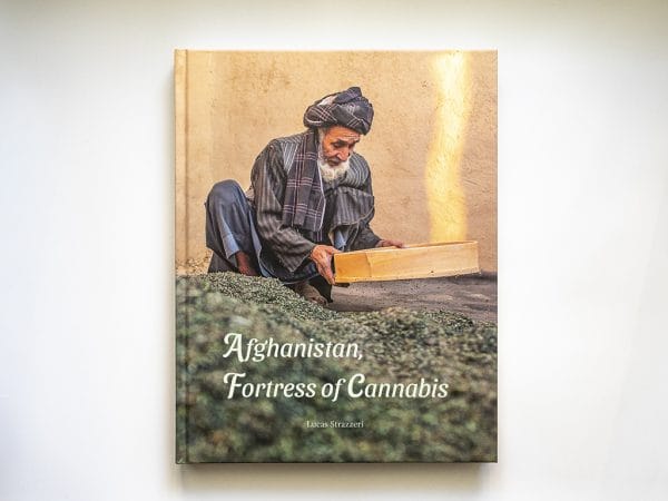 Photography book cover showing a man sieving dry cannabis in Afghanistan, symbolizing the country's traditional hashish culture.