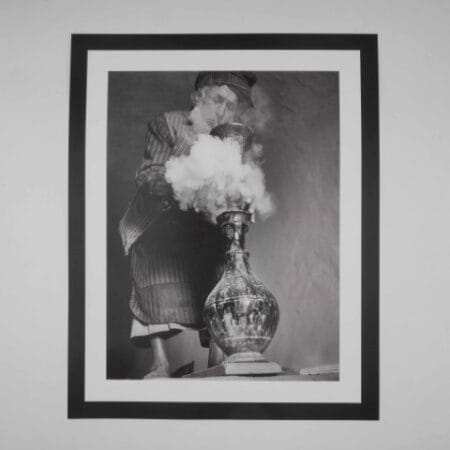 Black and white image of an Afghan man smoking hash through a traditional hookah
