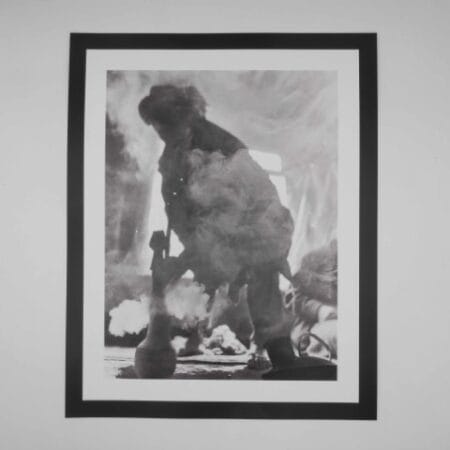 Black and white image of an Afghan man smoking hash through a traditional hookah